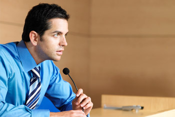 Image of a man speaking on a microphone