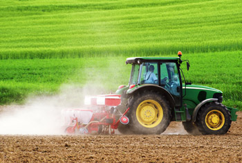 Image of tractor pulling tilling machinery