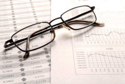 Image of a pair of glasses on top of financial paperwork