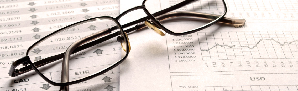 Image of a pair of glasses on top of financial paperwork
