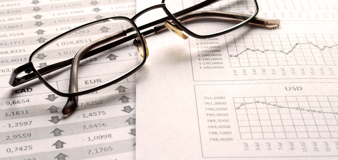 Image of a pair of glasses on top of financial paperwork